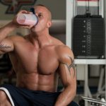 Bodybuilder drinking a protein-carbohydrate cocktail in a shaker